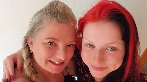 A teenager and a MILF p**s into each other’s mouths outdoors!